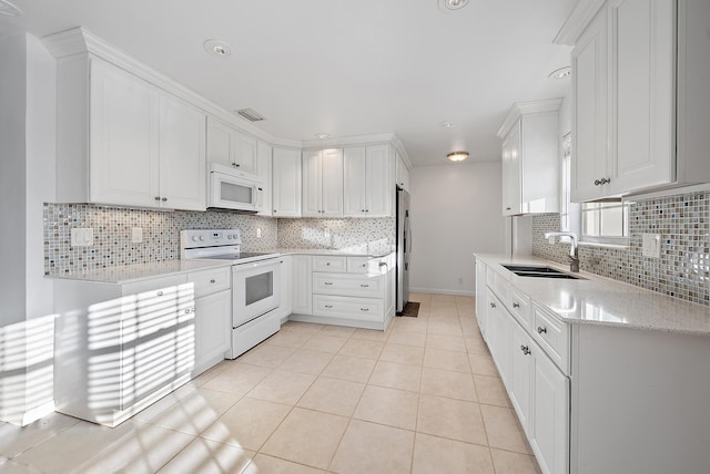 kitchen with white appliances, white cabinetry, and a sink