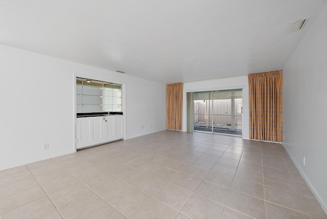 empty room with visible vents, baseboards, and light tile patterned flooring