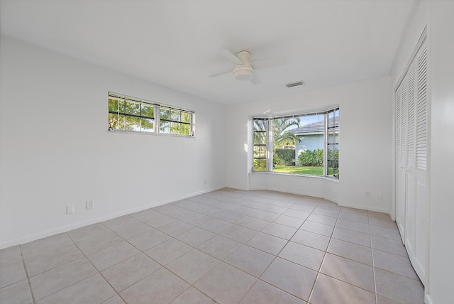 unfurnished room featuring a ceiling fan, baseboards, visible vents, and a wealth of natural light