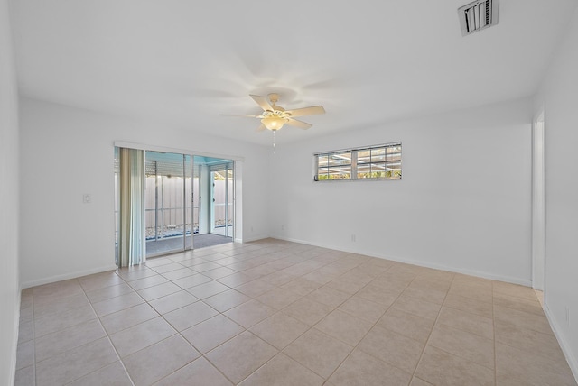 tiled spare room with ceiling fan, visible vents, and baseboards