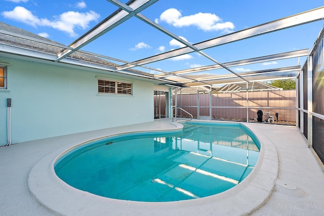 view of pool featuring a patio, a fenced backyard, and glass enclosure