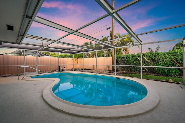 pool at dusk with a patio, a fenced backyard, glass enclosure, and a fenced in pool