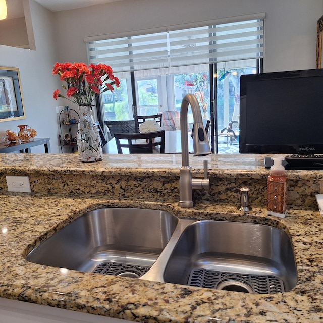 kitchen featuring light stone counters and a sink