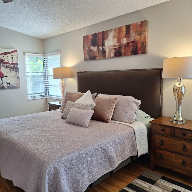 bedroom with a textured ceiling and wood finished floors