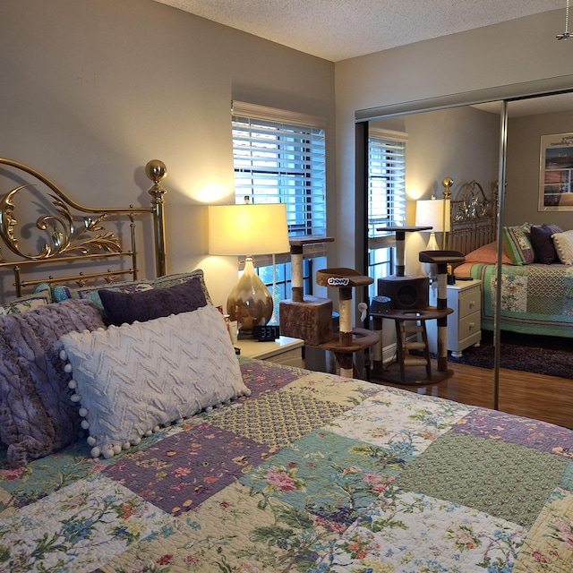 bedroom featuring a closet, a textured ceiling, and wood finished floors