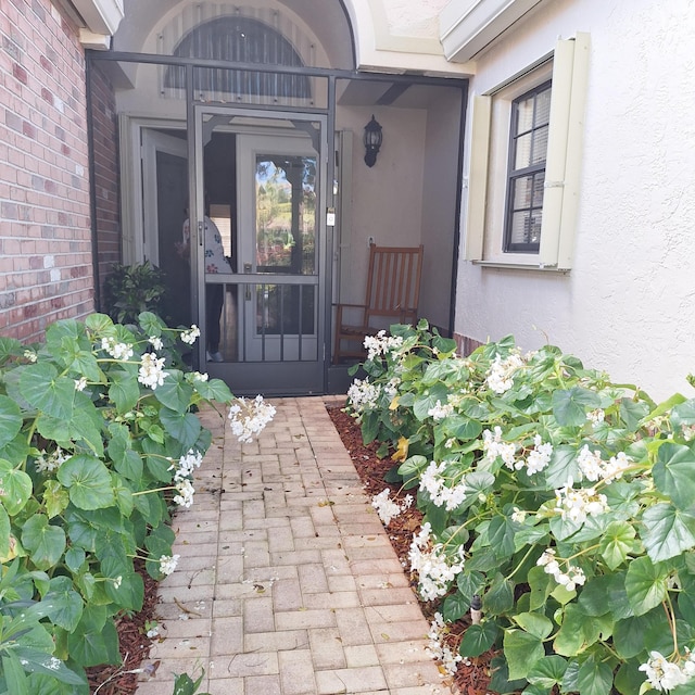 doorway to property with brick siding and stucco siding