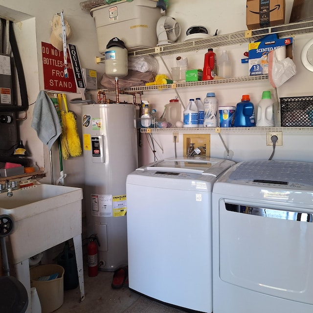 washroom featuring laundry area, washer and clothes dryer, and electric water heater