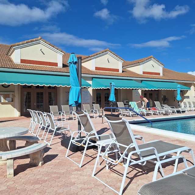 rear view of property featuring a patio area and a community pool