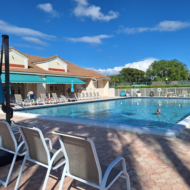 community pool featuring a patio and fence