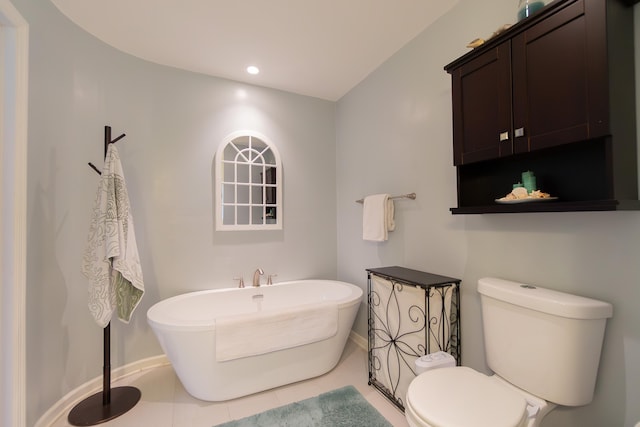 bathroom with baseboards, toilet, tile patterned flooring, a freestanding bath, and recessed lighting