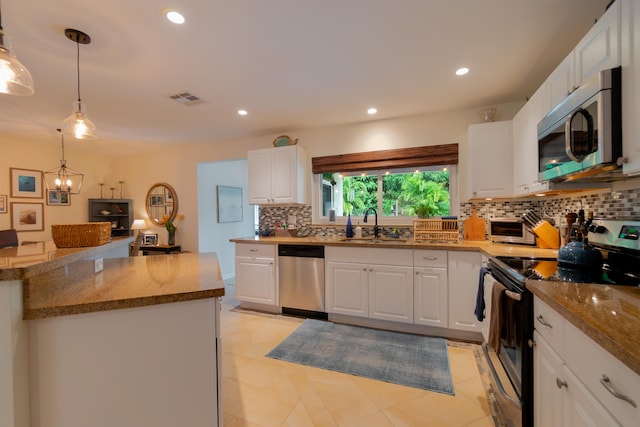 kitchen featuring appliances with stainless steel finishes, a sink, visible vents, and white cabinets