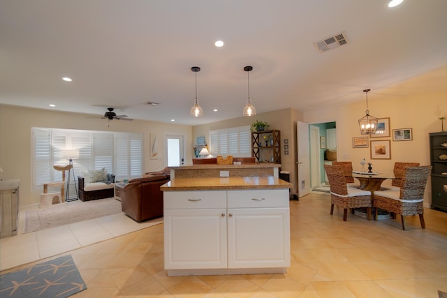 kitchen featuring recessed lighting, visible vents, hanging light fixtures, white cabinetry, and ceiling fan with notable chandelier