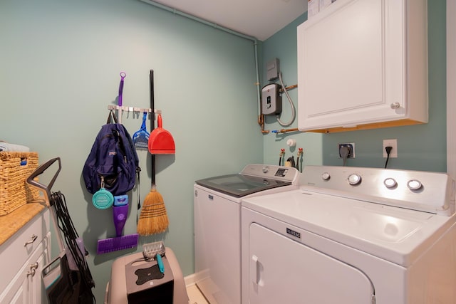 clothes washing area with washing machine and clothes dryer and cabinet space