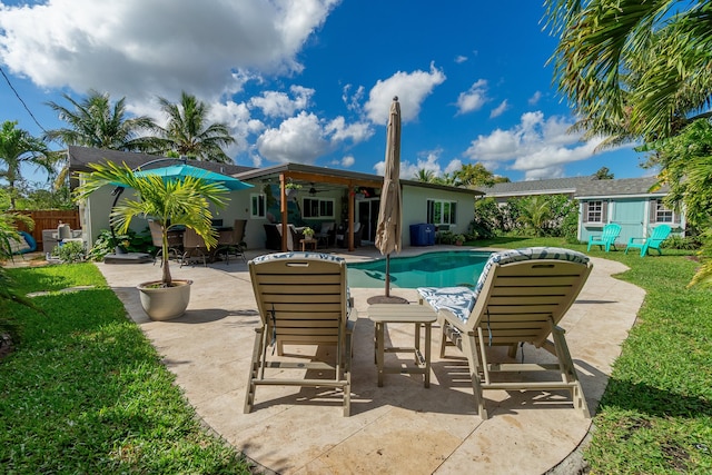 view of pool featuring a fenced in pool, ceiling fan, fence, a yard, and a patio area