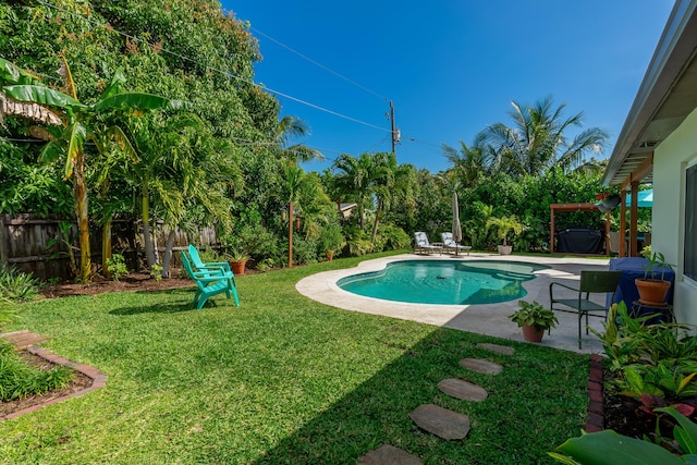 view of swimming pool featuring a patio area, a fenced backyard, a fenced in pool, and a lawn