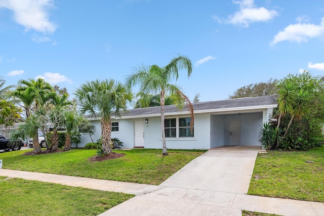 ranch-style house with an attached carport, driveway, a front lawn, and stucco siding