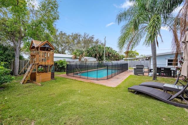 view of pool featuring a patio, a playground, a fenced backyard, a lawn, and a fenced in pool