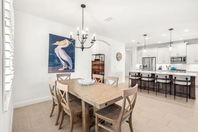 dining area featuring baseboards, visible vents, arched walkways, and recessed lighting