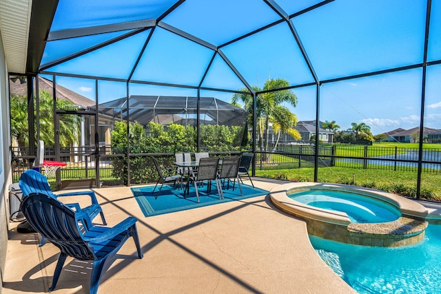 view of swimming pool featuring glass enclosure, a pool with connected hot tub, fence, and a patio