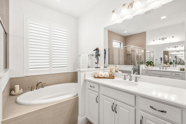 bathroom featuring a garden tub, a shower stall, and vanity