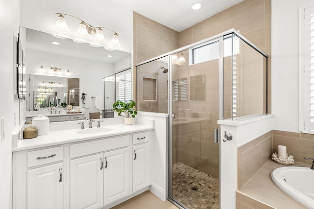 full bathroom with a garden tub, a shower stall, and vanity