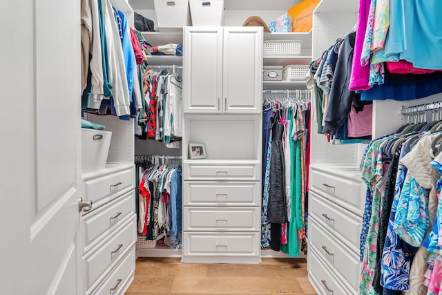 walk in closet with light wood-style flooring