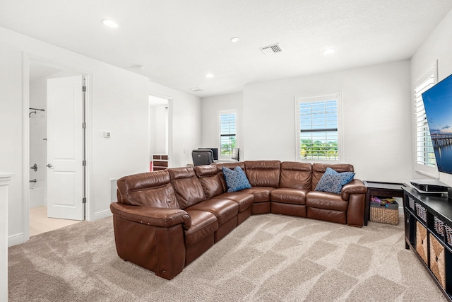 living area with light carpet, visible vents, and recessed lighting