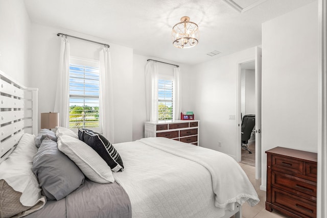 bedroom featuring multiple windows, visible vents, and a notable chandelier