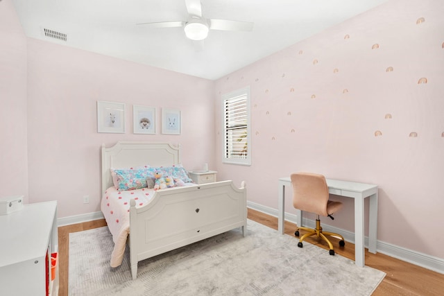 bedroom with visible vents, ceiling fan, baseboards, and wood finished floors