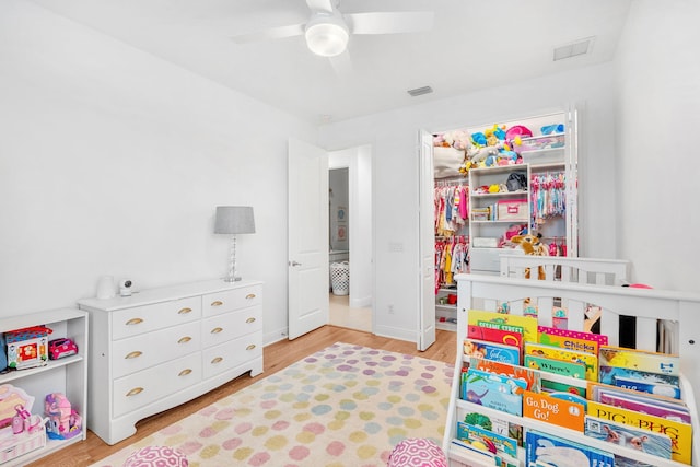 playroom featuring visible vents, ceiling fan, and wood finished floors