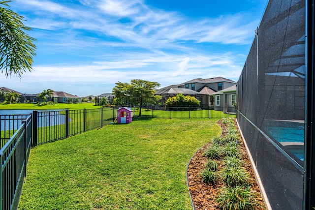 view of yard featuring glass enclosure, a fenced backyard, and a residential view