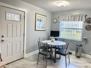 dining area with a textured ceiling and baseboards