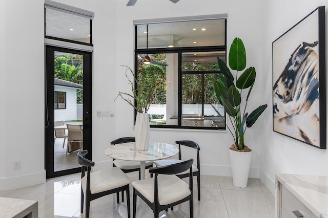 dining space featuring light tile patterned floors and baseboards