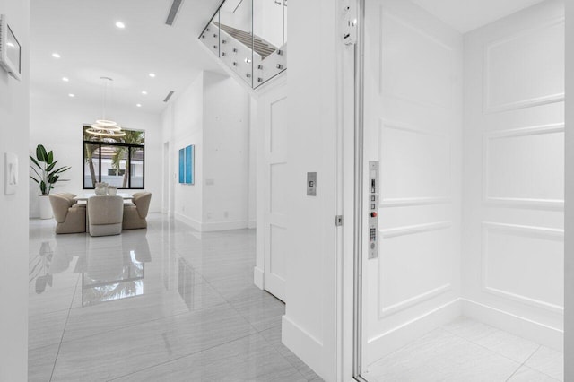 foyer entrance with baseboards, elevator, and recessed lighting