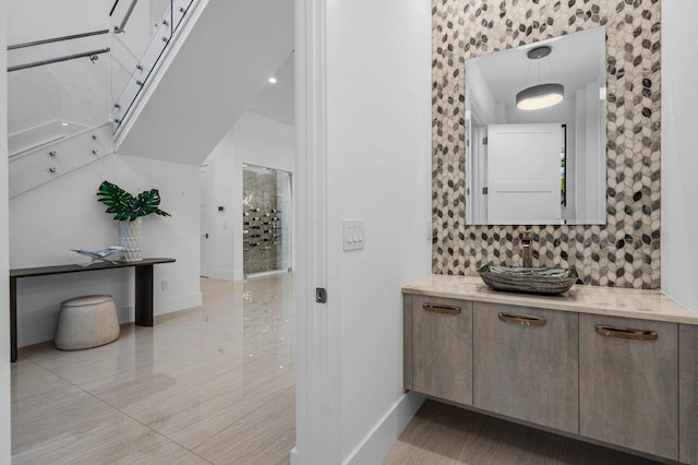 interior space with tasteful backsplash, a sink, and baseboards