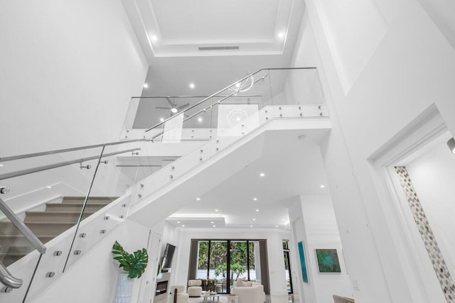 stairs with a towering ceiling and ornamental molding