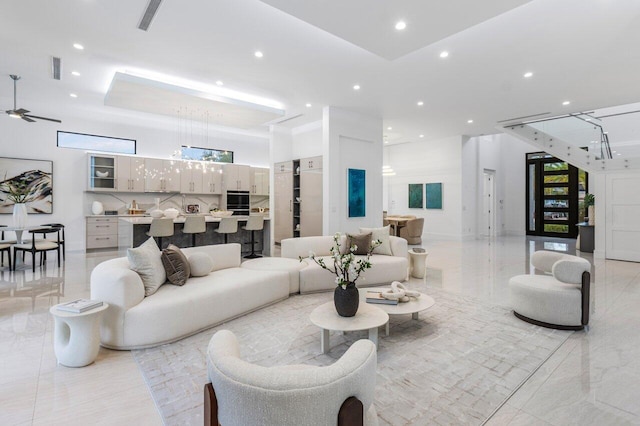 living room with marble finish floor, a high ceiling, visible vents, and recessed lighting