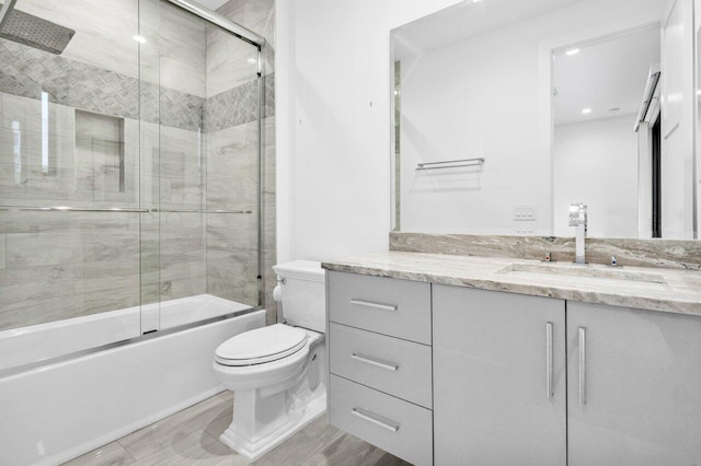 full bathroom with vanity, toilet, and bath / shower combo with glass door