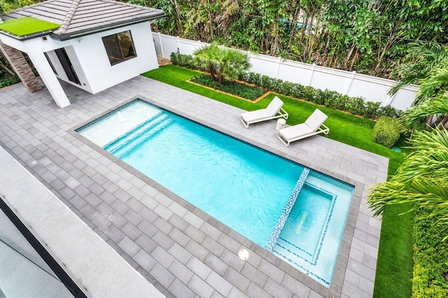 view of swimming pool featuring a patio area, a fenced backyard, a pool with connected hot tub, and a yard