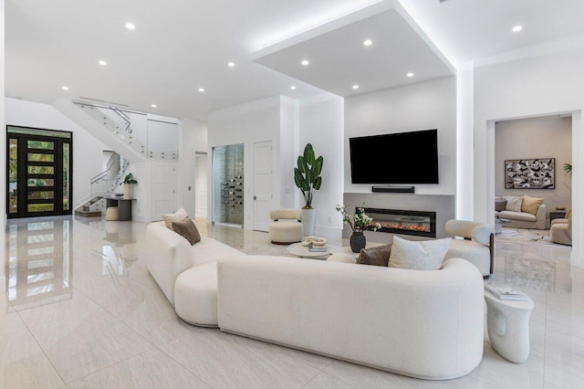 living area with recessed lighting, stairway, and a glass covered fireplace