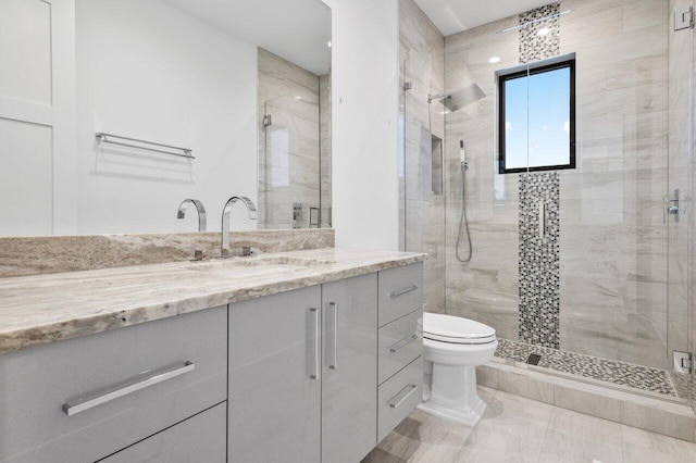 full bathroom with toilet, a shower stall, and vanity