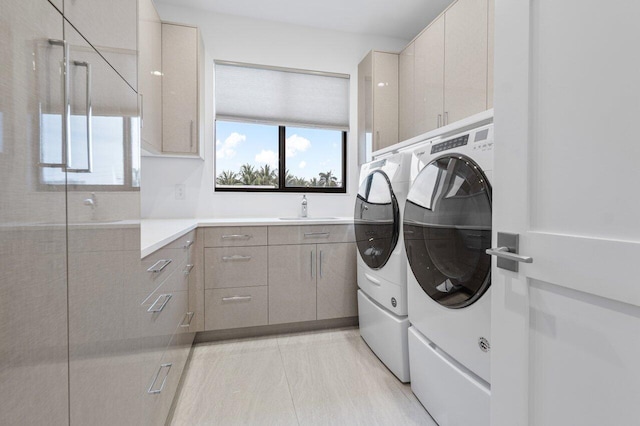 washroom with cabinet space, a sink, and separate washer and dryer