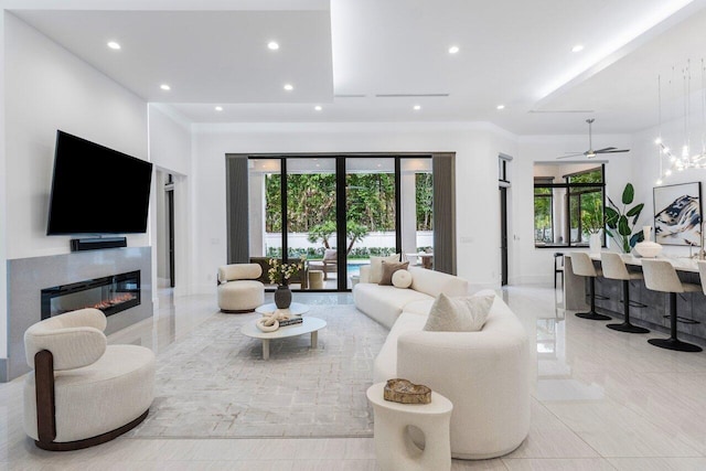 living room with a glass covered fireplace, marble finish floor, crown molding, and recessed lighting