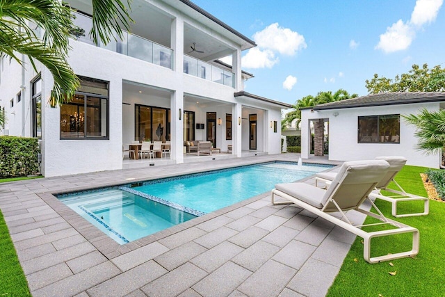 view of pool featuring a pool with connected hot tub, a patio area, ceiling fan, and outdoor lounge area