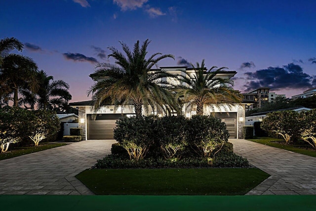 view of front of house featuring a garage, decorative driveway, and stone siding