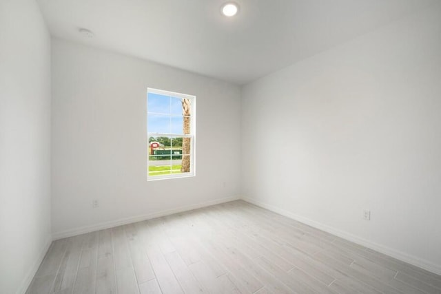 spare room with light wood-style flooring and baseboards