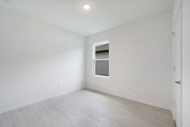 empty room with light wood-type flooring and baseboards