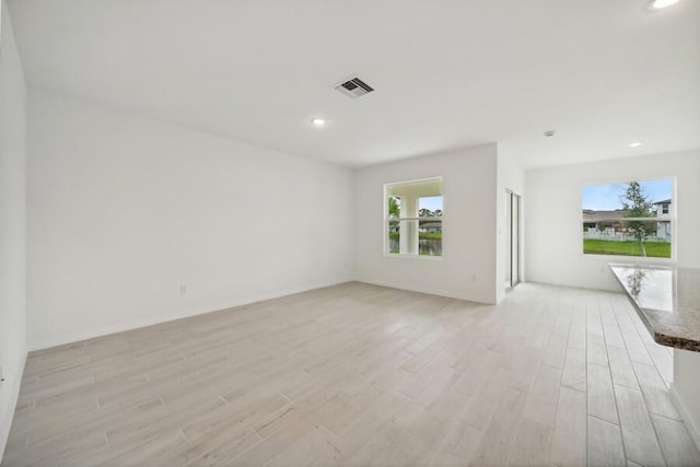 spare room with light wood-style flooring, visible vents, and recessed lighting