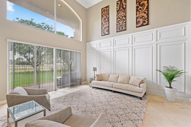 living room with a towering ceiling and crown molding