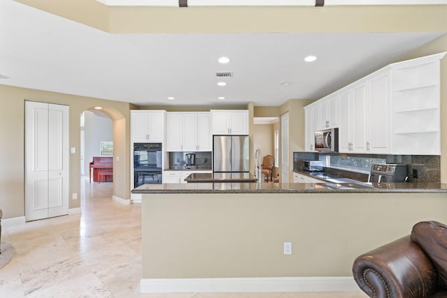 kitchen featuring a peninsula, open shelves, appliances with stainless steel finishes, and white cabinets